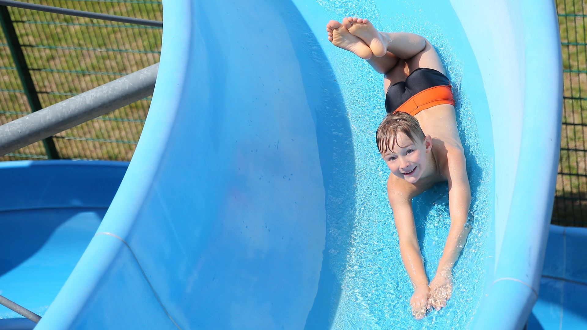 Kind rutscht Wasserrutsche runter