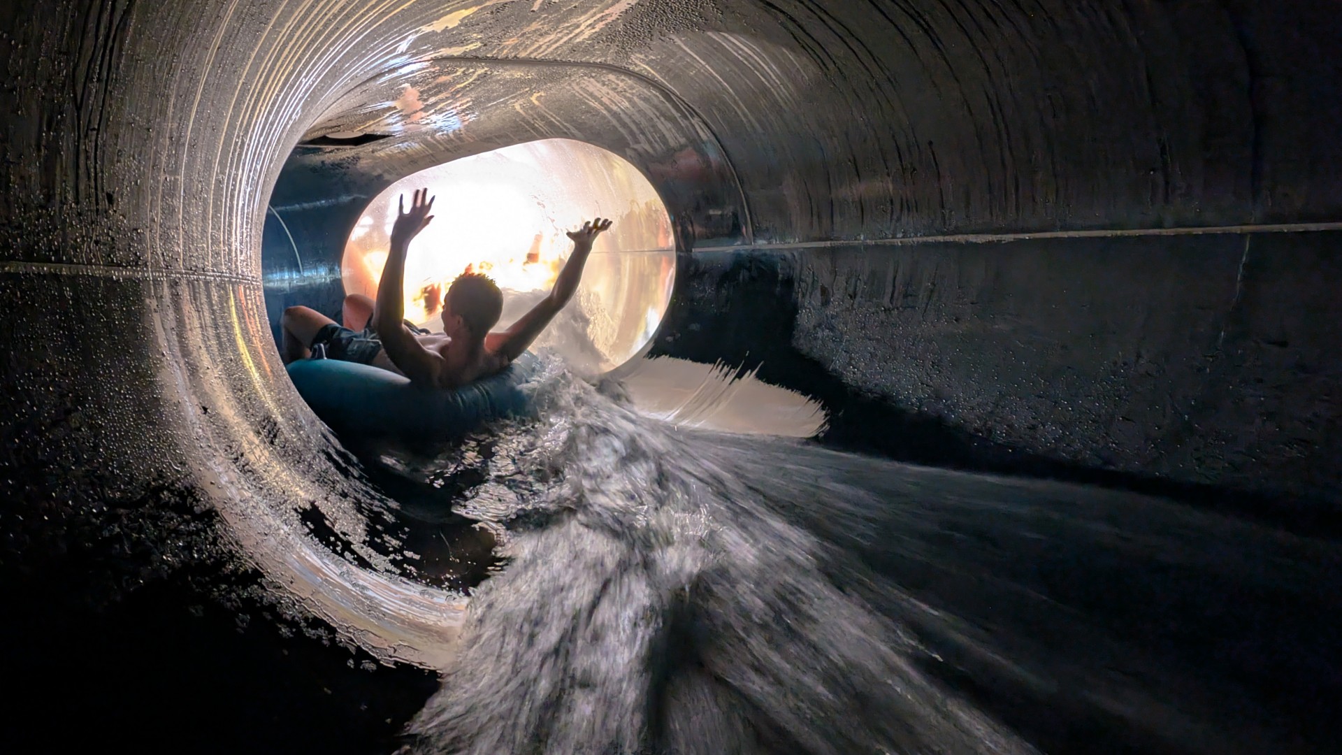 Person in der Röhrenrutsche im blu am Fake mit LED-Panel, © Martin Riek