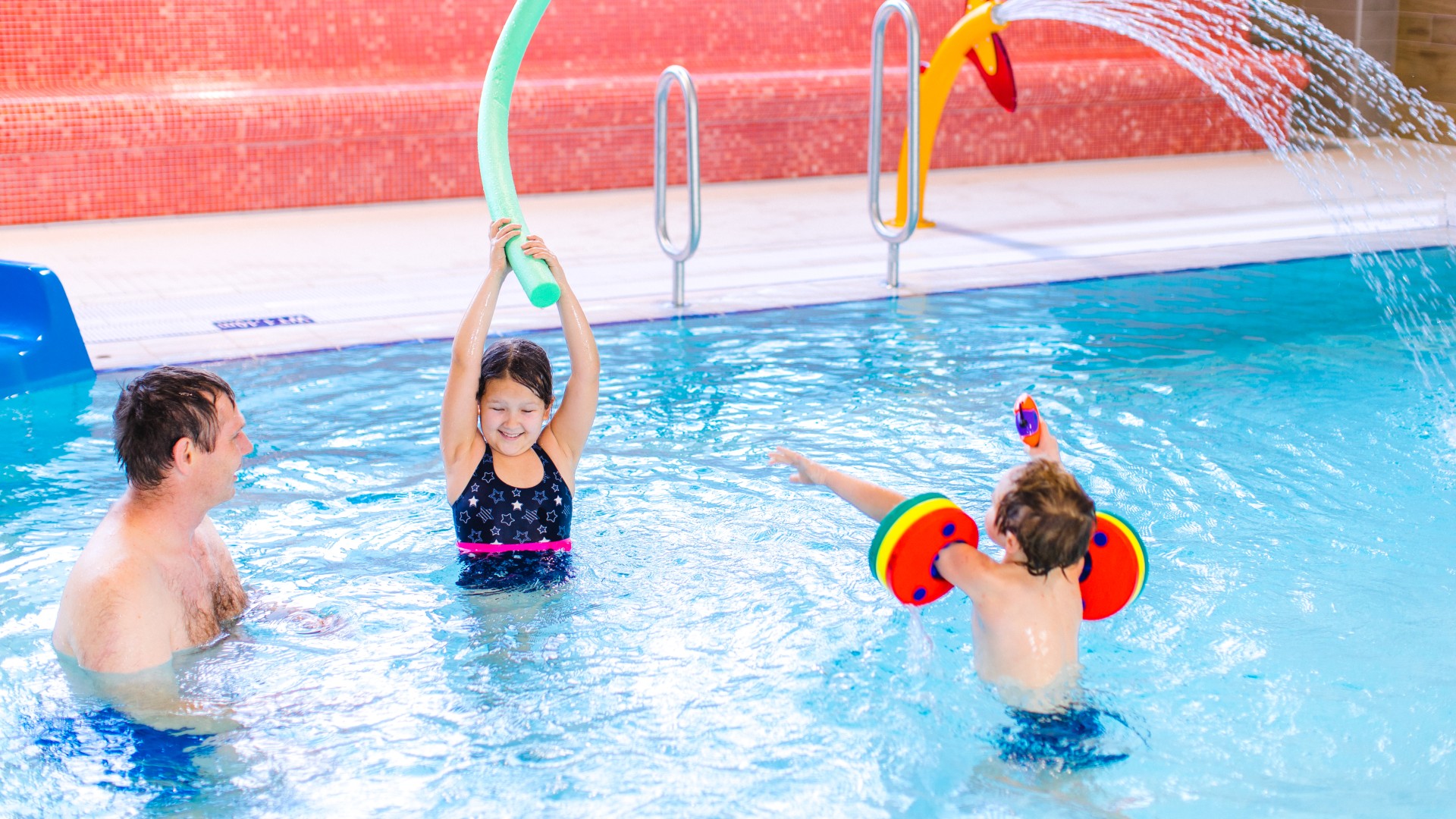 Zwei Kinder und ein Familienvater planschen im Kiezbad, © Alena Suber