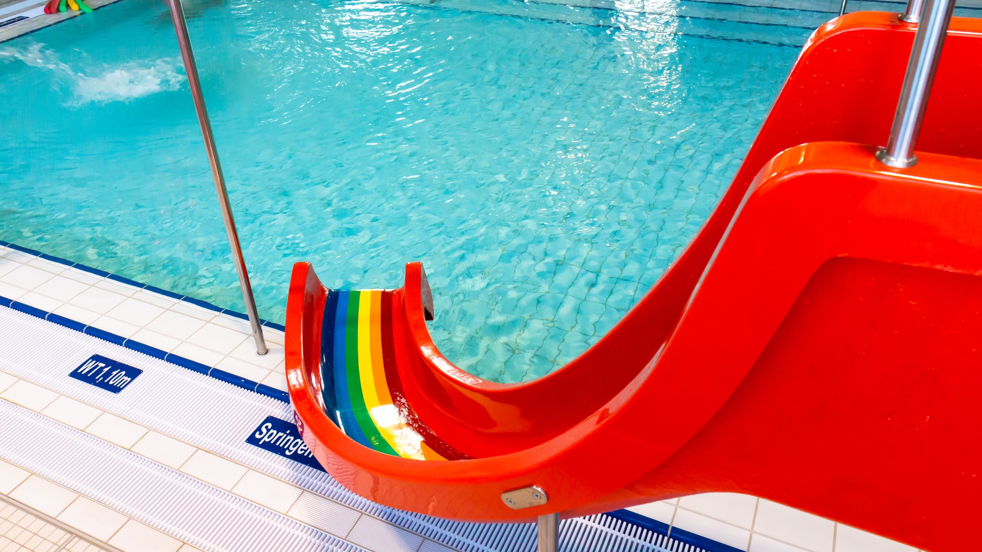 Rote Kinderrutsche mit Regenbogenfarben im Kiezbad Am Stern