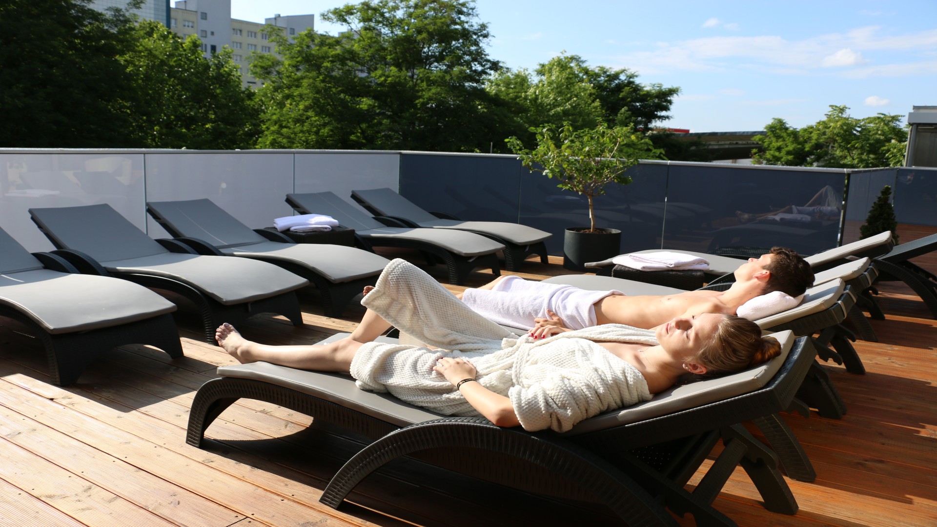 Junges Paar liegt auf Sonnenliegen auf der Dachterreasse des Kiezbades Am Stern, © Jan Seelig