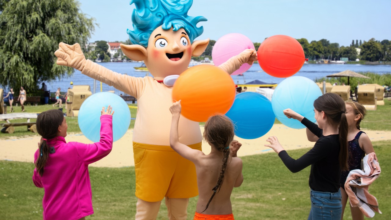 Willi Welle und vier Kinder mit großen bunten Luftballons im Stadtbad Park Babelsberg
