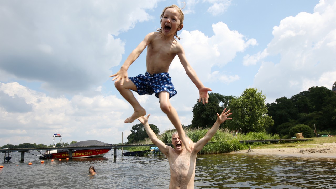 Vater und Sohn spielen im Wasser im Stadbad Park Babelsberg