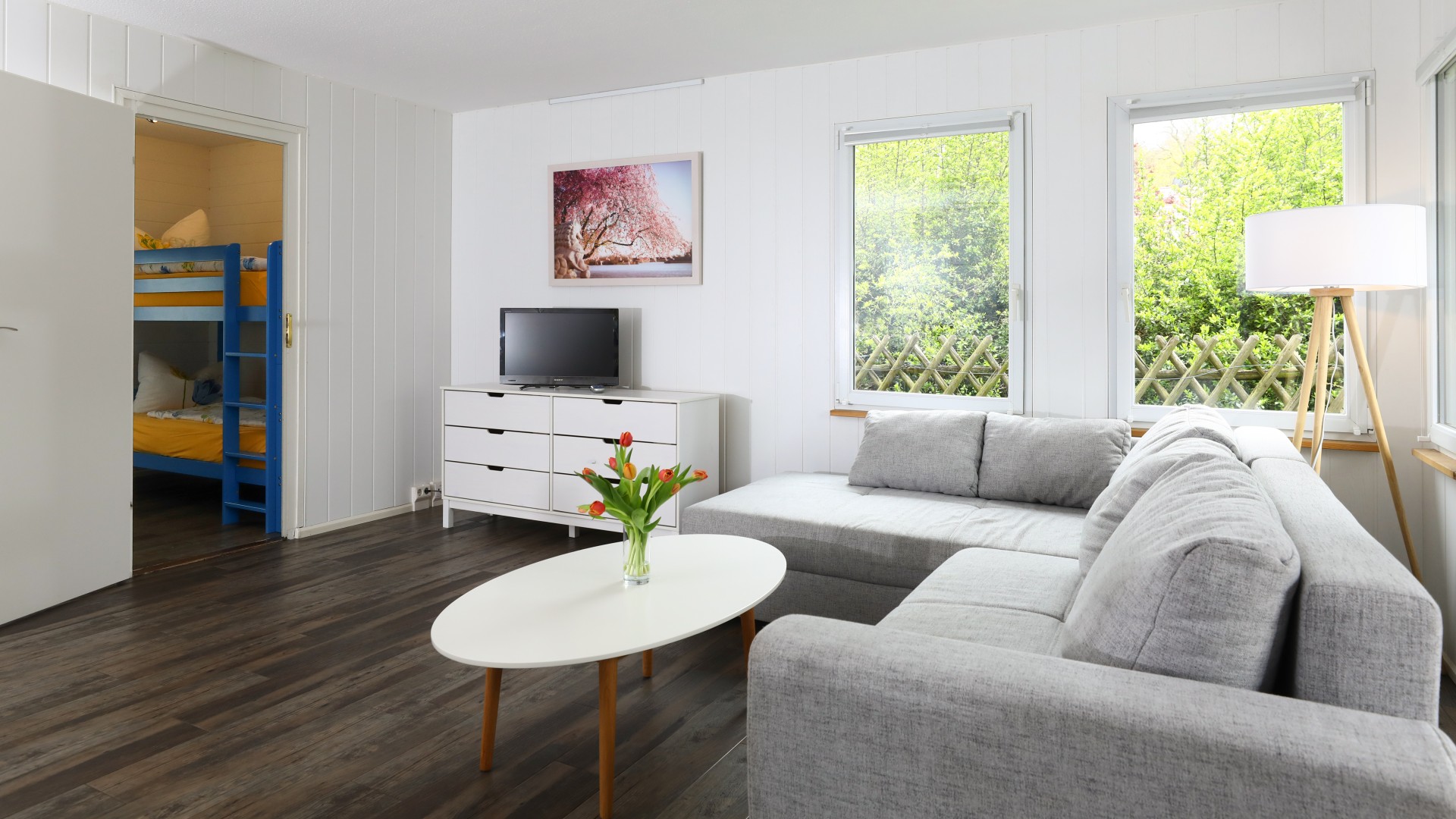 Wohnbereich mit Couch, Tisch und TV im Bungalow Waldbad Templin, © Kathleen Friedrich