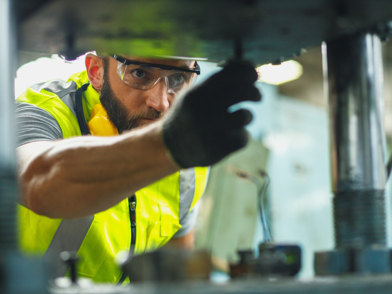 Nahaufnahme einer Hand eines Ingenieurs, der an einer Industriemaschinen in einer Fabrik arbeitet., © KPs Photography – stock.adobe.com