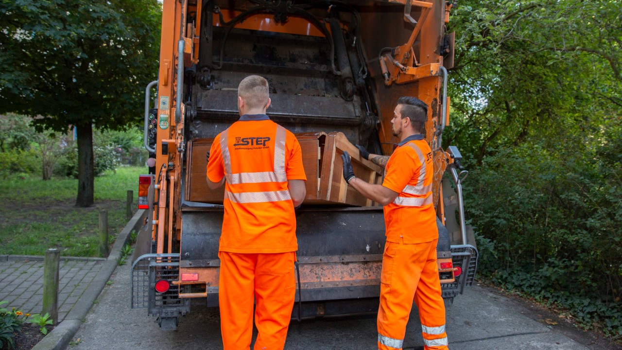 zwei STEP-Mitarbeiter verladen Sperrmüll