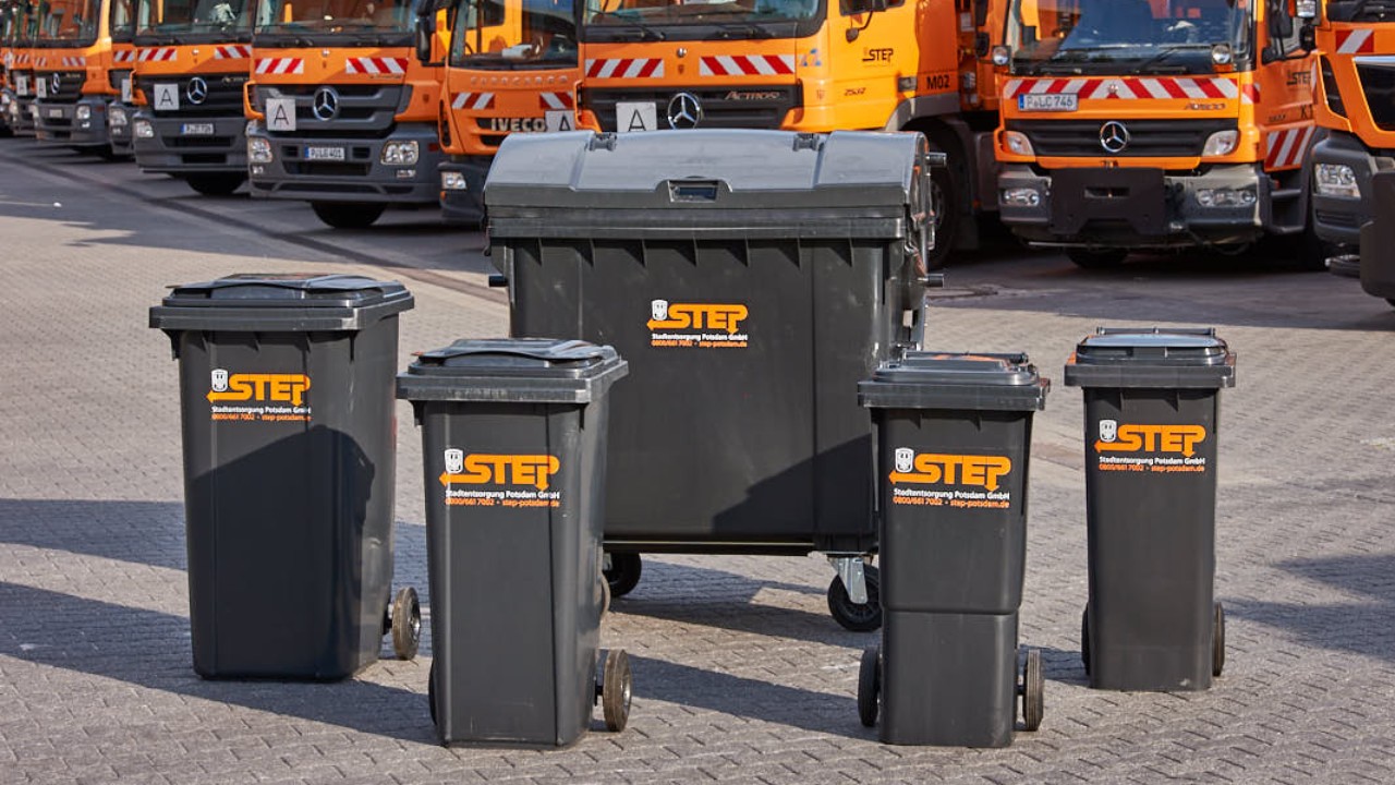 verschiedene Restabfalltonnen vorm Fuhrpark der STEP