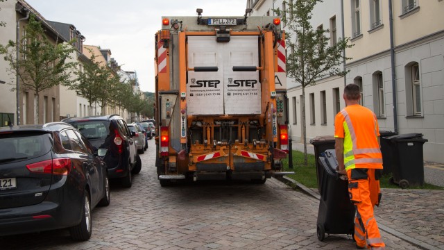 STEP-Entsorgungsfahrzeug in Babelsberg, ein Mitarbeiter schiebt eine Restmülltonne Richtung Fahrzeug