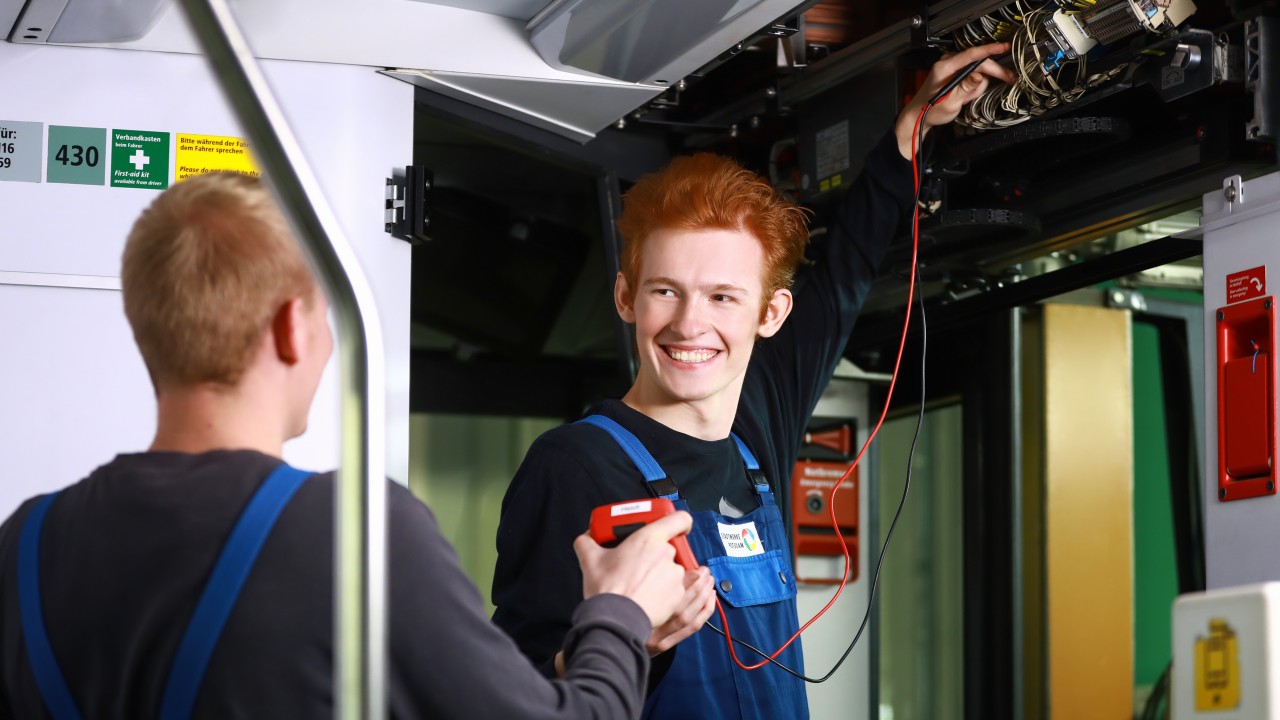 Kollege reicht Elektroniker für Betriebstechnik Prüfgerät, © Kathleen Friedrich