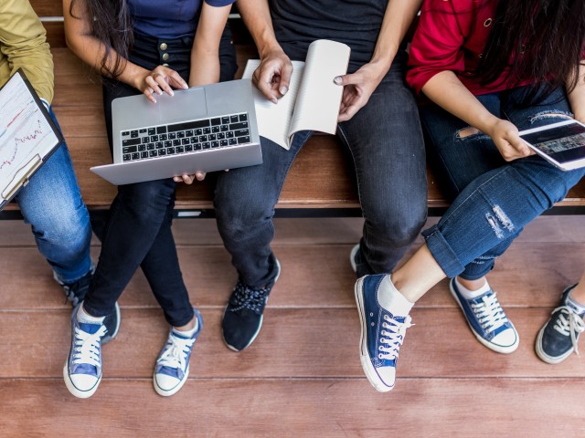 Junge Menschen mit Laptop und Hefter von oben aufgenommen