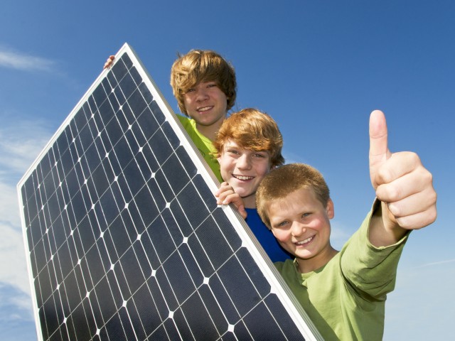 zwei Kinder halten ein Solarpaneel