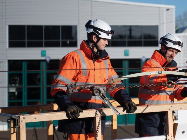 Mitarbeiter im Bereich Infrastruktur bei der Arbeit an Fahrleitungsmasten